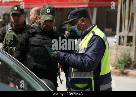 23 marzo 2020: Jenin, West bank. 23 marzo 2020. I membri delle forze di sicurezza nazionali palestinesi hanno costituito una barriera e hanno fatto controlli all'ingresso della città di Jenin per applicare l'attuazione di nuove misure restrittive contro la diffusione del coronavirus in Cisgiordania. Domenica il primo Ministro palestinese ha ordinato un divieto di due settimane su tutti i movimenti non essenziali per contenere la diffusione di Covid-19, mentre il numero di casi confermati in Cisgiordania è salito a 57 Credit: Mohammed Turabi/IMAGESLIVE/ZUMA Wire/Alamy Live News Foto Stock