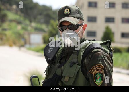 23 marzo 2020: Jenin, West bank. 23 marzo 2020. I membri delle forze di sicurezza nazionali palestinesi hanno costituito una barriera e hanno fatto controlli all'ingresso della città di Jenin per applicare l'attuazione di nuove misure restrittive contro la diffusione del coronavirus in Cisgiordania. Domenica il primo Ministro palestinese ha ordinato un divieto di due settimane su tutti i movimenti non essenziali per contenere la diffusione di Covid-19, mentre il numero di casi confermati in Cisgiordania è salito a 57 (Credit Image: © Mohammed Turabi/IMAGESLIVE via ZUMA Wire) Foto Stock