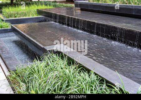 Piccola cascata nel cortile all'aperto. Water Feature come parte del Landscape Design. Foto Stock