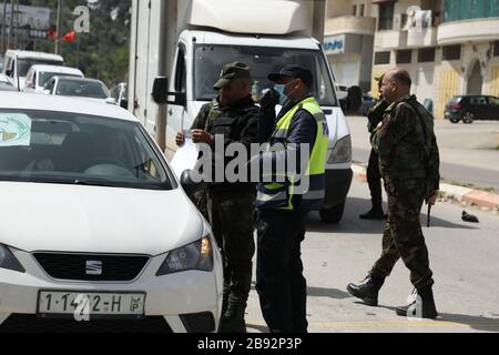 23 marzo 2020: Jenin, West bank. 23 marzo 2020. I membri delle forze di sicurezza nazionali palestinesi hanno costituito una barriera e hanno fatto controlli all'ingresso della città di Jenin per applicare l'attuazione di nuove misure restrittive contro la diffusione del coronavirus in Cisgiordania. Domenica il primo Ministro palestinese ha ordinato un divieto di due settimane su tutti i movimenti non essenziali per contenere la diffusione di Covid-19, mentre il numero di casi confermati in Cisgiordania è salito a 57 Credit: Mohammed Turabi/IMAGESLIVE/ZUMA Wire/Alamy Live News Foto Stock