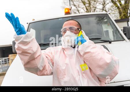 L'infermiere antivirologo sta discutendo sullo smartphone durante l'emergenza sanitaria del coronavirus all'aperto Foto Stock