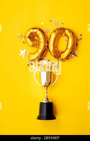 Palloncino numero 90 per la celebrazione dell'anniversario d'oro che esplode da un trofeo vincente Foto Stock