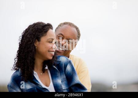 Coppia sorridente felicemente sulla spiaggia Foto Stock