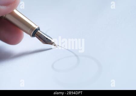 Mano dell'uomo con firma della penna della fontana, primo piano Foto Stock