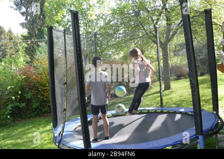 Fratello e sorella saltano sul trampolino Foto Stock