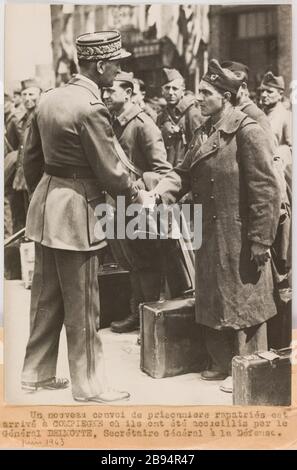 Propaganda fotografica: Il generale Delmotte, segretario generale della difesa, scrolla le mani con un prigioniero rimpatriato, Compiegne. Trampus. «Photographie propagande : le général Delmotte, secrétaire général à la Défense, serre la main à un prigionier rapatrié, Compiègne». Un nouveau convoi de prigioniero rapatriés est / arrivé à COMPIEGNE où ils ont été accueillis par le / Général DELMOTTE, secrétaire Général à la Défense. Tigre au gélatino-bromure d'argent. à de l'encre noire. En 1943-06-11-1943-06-11. Parigi, musée Carnavalet. Foto Stock