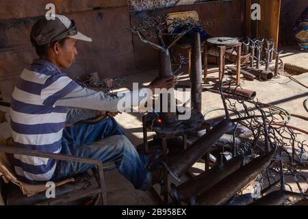 Saldatore nell'impresa sociale e solidale della lavorazione del metallo con materiale riciclato creato da Violette e Dieudonne ad Antananarivo Foto Stock