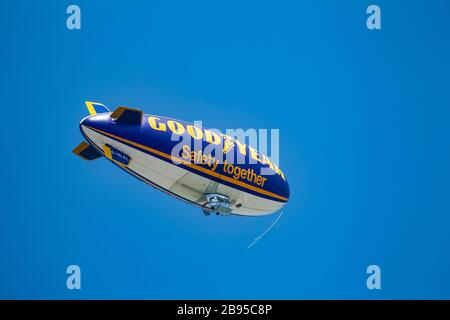 La nave Good Year (blimp) che sorvola lo Yorkshire occidentale, nel Regno Unito, contro un cielo blu chiaro durante il tragitto per la televisione di un evento sportivo Foto Stock