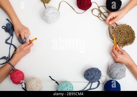 Palle di filato di colore diverso. Le mani dei bambini sono accovacciate e la vista del filetto sopra con posto per il testo Foto Stock