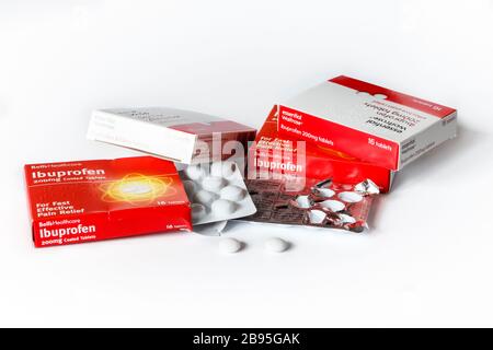 Scatole di compresse di ibuprofene e confezioni blister, due compresse rimosse, su sfondo bianco Foto Stock