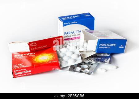 Scatole di compresse di ibuprofene e paracetamolo e blister, due compresse rimosse, su sfondo bianco Foto Stock