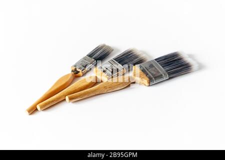 Tre pennelli in nylon con setole in legno su sfondo bianco Foto Stock