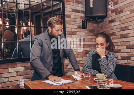 L'uomo elegante, bello, barbuto, infelice è fuori da sé a causa di crisi, rovina, devastazione dell'azienda, tenendo carta stropicciata in mano, incontro dentro Foto Stock