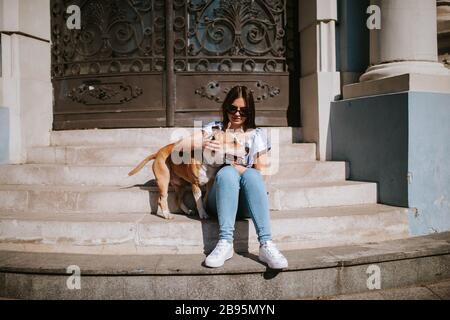 Una giovane bella ragazza e il suo cane sulle scale Foto Stock