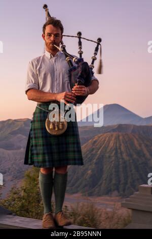 Ross Jennings in Scottish Kilt che gioca con le cornamuse al Monte bromo in Indonesia all'alba. Era una scena spettacolare con la musica d'ambiente. Foto Stock