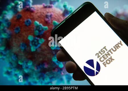 In questa illustrazione della foto, il logo Fox della multinazionale americana dei mass media del ventunesimo secolo visualizzato su uno smartphone con un modello di computer del coronavirus COVID-19 sullo sfondo. Foto Stock