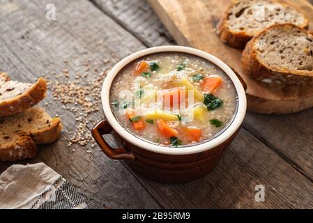 Krupnik, zuppa d'orzo polacca con verdure su sfondo ligneo Foto Stock