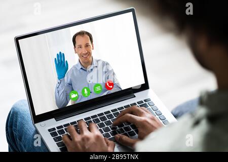 Uomo in quarantena di Coronavirus che utilizza la videoconferenza per lavorare da casa Foto Stock