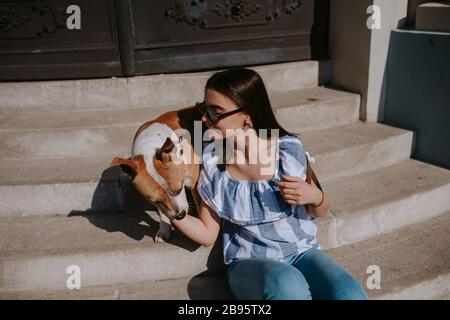 Una giovane bella ragazza e il suo cane sulle scale Foto Stock