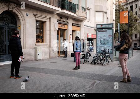 Barcellona, Spagna. 18 Marzo 2020. La gente si allinea per comprare il pane mentre mantiene la loro distanza l'uno dall'altro durante la crisi di coronavirus.poiché lo stato di allarme è stato decretato durante tutta la Spagna dovuto l'aumento delle infezioni di coronavirus, più di 30,000 genti sono state diagnosticate e 2,200 sono morti a causa di Covid19. Le autorità hanno ordinato a tutti i cittadini di rimanere a casa e di andare solo a comprare cibo o medicine, nel rispetto delle regole del distanziamento sociale. Credit: Pablo Miranzo/SOPA Images/ZUMA Wire/Alamy Live News Foto Stock