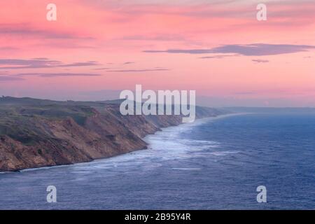 Vista di Manukau Heads al crepuscolo, come visto dalla pista di Omanawanui a Whatipu, Nuova Zelanda Foto Stock