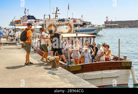 AMALFI, ITALIA - AGOSTO 2019: Persone che scendono da una piccola barca a motore dopo una crociera lungo la Costiera Amalfitana Foto Stock