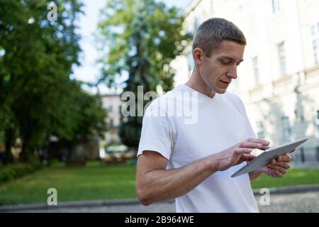 uomo creativo nel centro della città e utilizzando un computer tablet Foto Stock