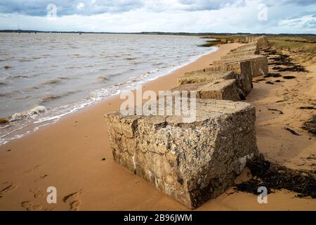 Blocchi di cemento anti-invasione accanto al fiume Deben, Bawdsey Ferry, Suffolk, Regno Unito. Foto Stock