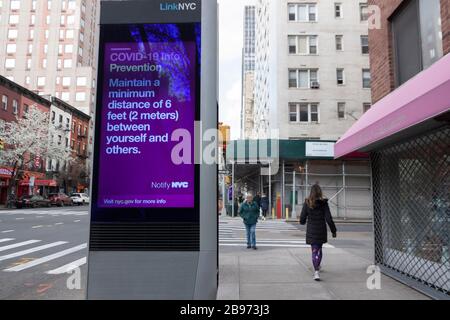 LinkNYC digital Kiosk segno sul marciapiede che mostra Covid-19 (coronavirus) messaggi e consigli su distancing sociale a New Yorkers. Foto Stock