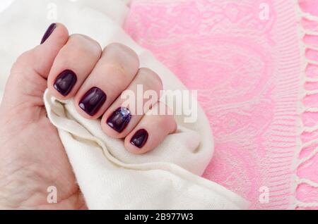 Mano di una donna adulta con unghie dipinte, manicure, smalto per unghie. Foto studio Foto Stock