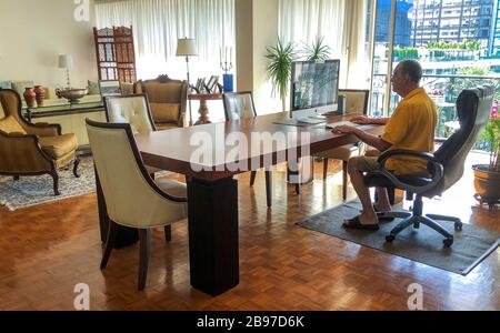 Uomo al computer che lavora da casa Foto Stock