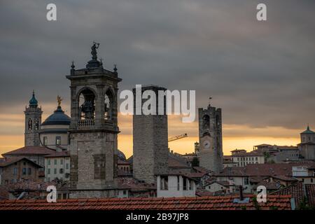 Bergamo al tramonto nella città vecchia con le torri e la torre campanaria Foto Stock