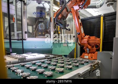 il robot al lavoro prende un pezzo di alluminio Foto Stock