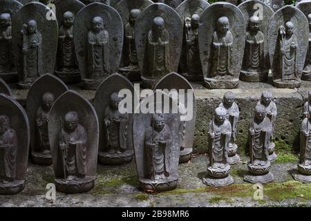 Kamakura, Giappone - 19 maggio 2019: File di statue in pietra Jizo Bodhisattva nel tempio Hase-Dera di Kamakura, Giappone. Jizo è speciale per le donne incinte A. Foto Stock