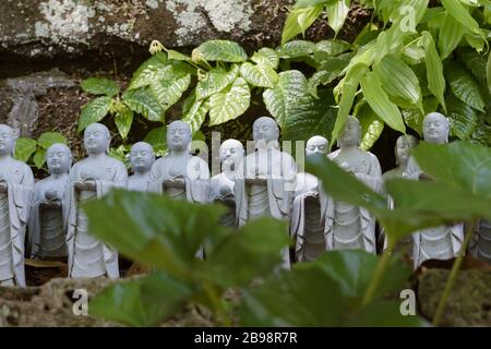 Kamakura, Giappone - 19 maggio 2019: File di statue in pietra Jizo Bodhisattva nel tempio Hase-Dera di Kamakura, Giappone. Jizo è speciale per le donne incinte A. Foto Stock