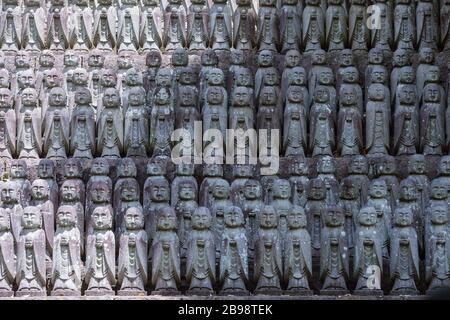 Kamakura, Giappone - 19 maggio 2019: File di statue in pietra Jizo Bodhisattva nel tempio Hase-Dera di Kamakura, Giappone. Jizo è speciale per le donne incinte A. Foto Stock