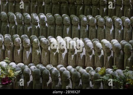 Kamakura, Giappone - 19 maggio 2019: File di statue in pietra Jizo Bodhisattva nel tempio Hase-Dera di Kamakura, Giappone. Jizo è speciale per le donne incinte A. Foto Stock