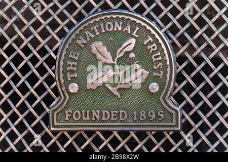 Green 'The National Trust Founded 1895' distintivo auto in metallo cromato d'epoca con simbolo di foglia di quercia montato sulla griglia del radiatore in rete metallica della macchina Austin Morris. Foto Stock