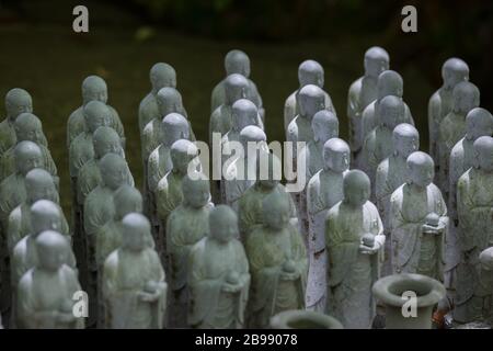 Kamakura, Giappone - 19 maggio 2019: File di statue in pietra Jizo Bodhisattva nel tempio Hase-Dera di Kamakura, Giappone. Jizo è speciale per le donne incinte A. Foto Stock