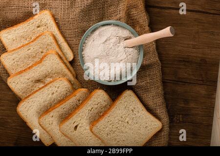 Una ciotola di farina con fette di pane Foto Stock