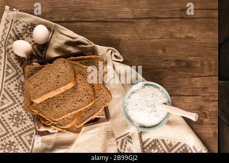 Uova con fette di pane e ciotola di farina Foto Stock