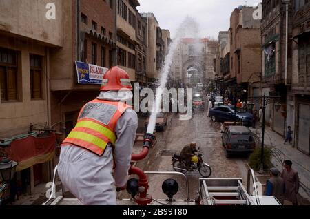 Peshawar, Pakistan. 23 marzo 2020. Un soccorritore disinfetta le strade di Peshawar nel tentativo di frenare la diffusione dell'epidemia di virus corona. La stragrande maggioranza della gente si recupera dal nuovo virus della corona. Secondo l'Organizzazione Mondiale della Sanità, la maggior parte delle persone si ritrovano in circa due o sei settimane, a seconda della gravità della malattia. Credit: SOPA Images Limited/Alamy Live News Foto Stock