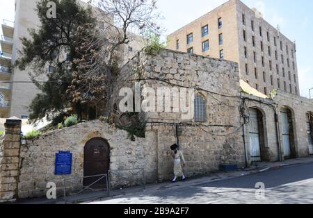 Un uomo ebraico assidico che cammina per lo storico edificio dell'ospedale per bambini marienstift in via ha-Neviim a Gerusalemme. Foto Stock