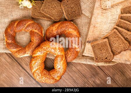 Bagel e fette di pane nel cesto e sulla tovaglia Foto Stock