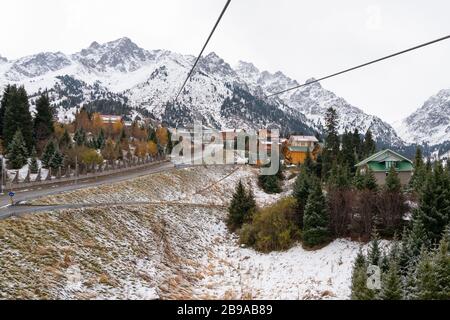 Stazione sciistica di montagna vicino alla cima di Shymbulak coperta di neve. Meta popolare per turisti e locali vicino Almaty, Kazakhstan. Case di legno. Foto Stock