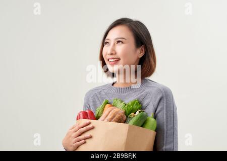 Donna allegra tenendo un sacchetto della spesa pieno di negozi di generi alimentari Foto Stock