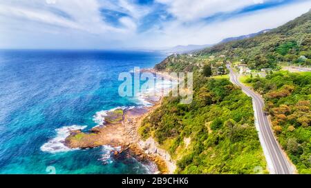 La costa panoramica dell'Australia lungo il Grand Pacific Drive in vista aerea elevata verso sud in una giornata di sole. Foto Stock