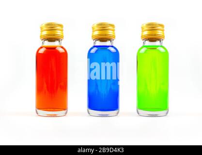 Colorazione alimentare in bottiglie di vetro su sfondo bianco isolato, giallo, blu, verde, tre bottiglie di colorazione alimentare Foto Stock
