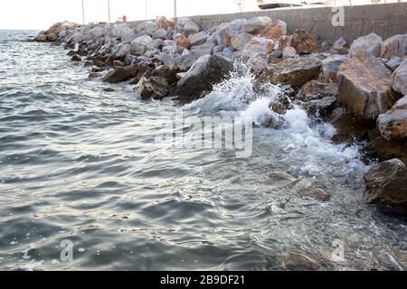 Onde che colpiscono le rocce sulla riva. Foto Stock