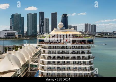 Miami, FL, Stati Uniti - 20 aprile 2019: La nave da crociera Celebrity Equinox è ormeggiata al terminal delle navi da crociera di Miami con grattacieli sullo sfondo A. Foto Stock